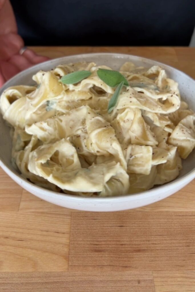 A bowl of Giada De Laurentiis Cauliflower Alfredo with a fork.