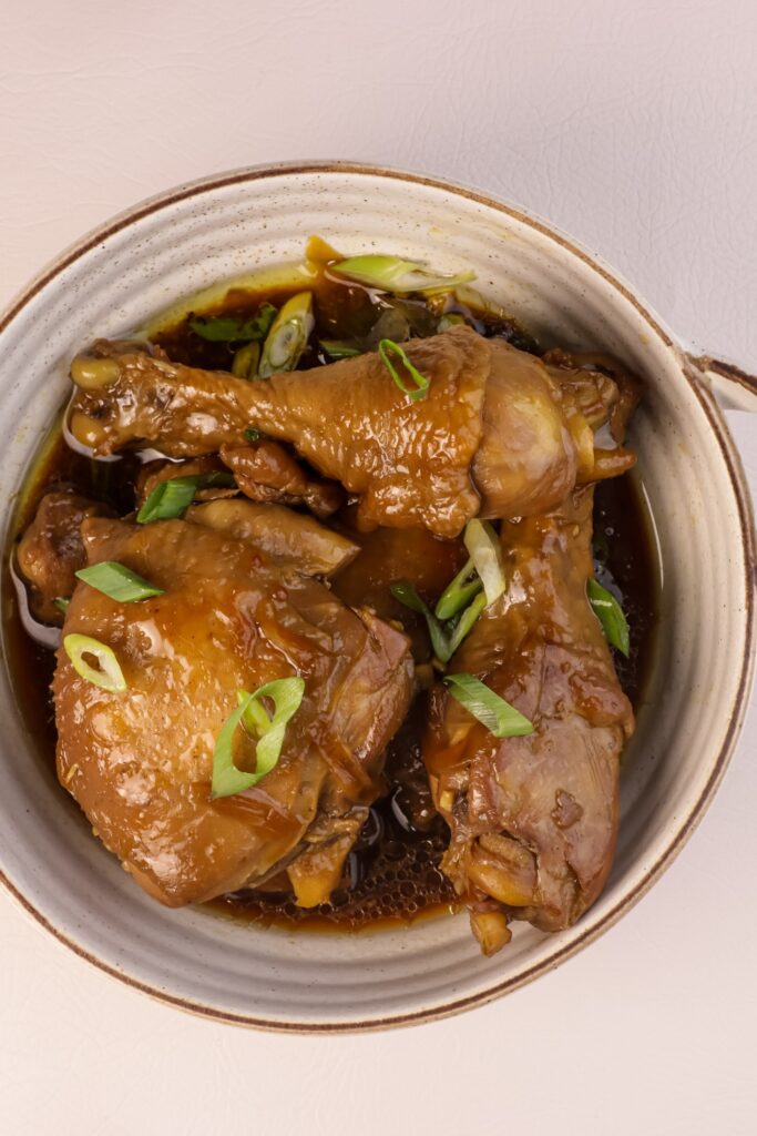 Chicken Adobo in a bowl garnished with green onions.