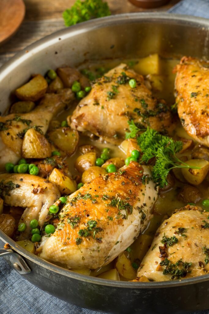 Giada De Laurentiis Chicken Vesuvio with potatoes and peas in a skillet.