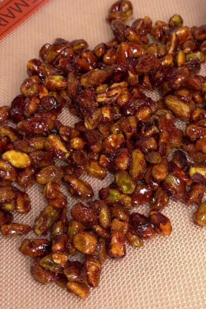 Candied pistachios cooling on a silicone mat.