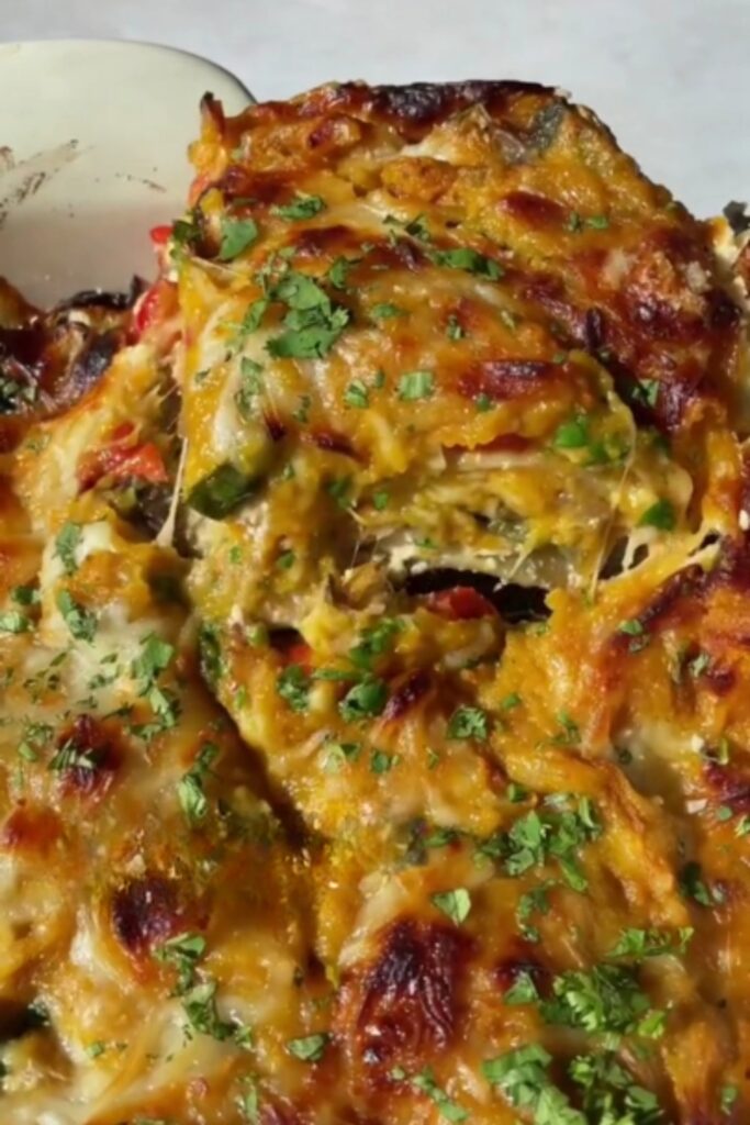 a serving of butternut squash lasagna with a golden-brown top and sprinkled herbs.