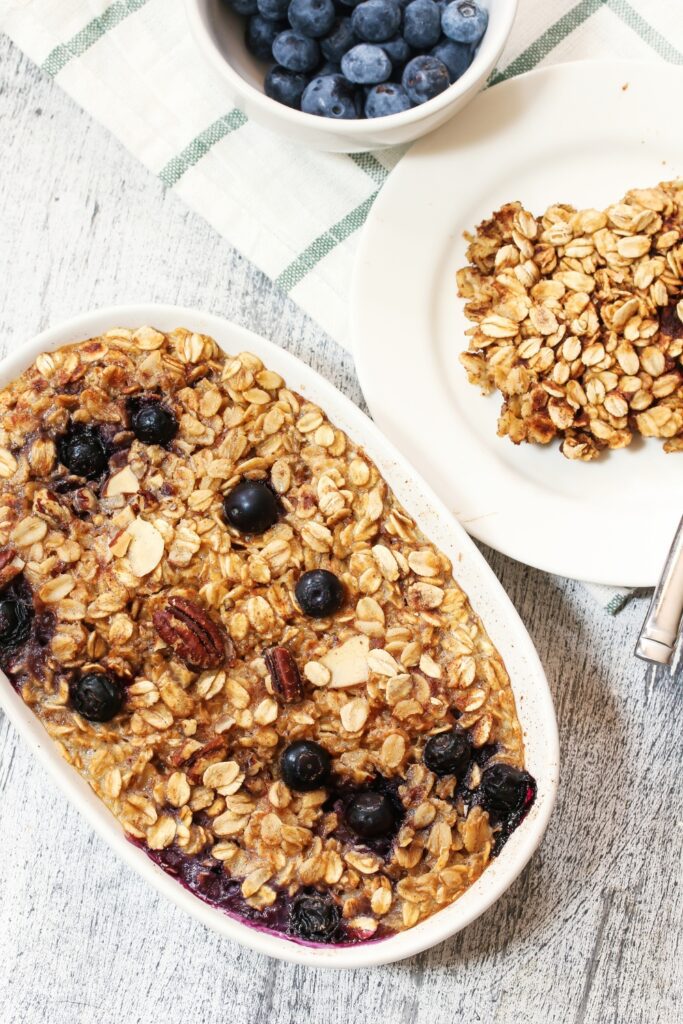 Giada De Laurentiis baked oatmeal served on a plate with blueberries on the side.