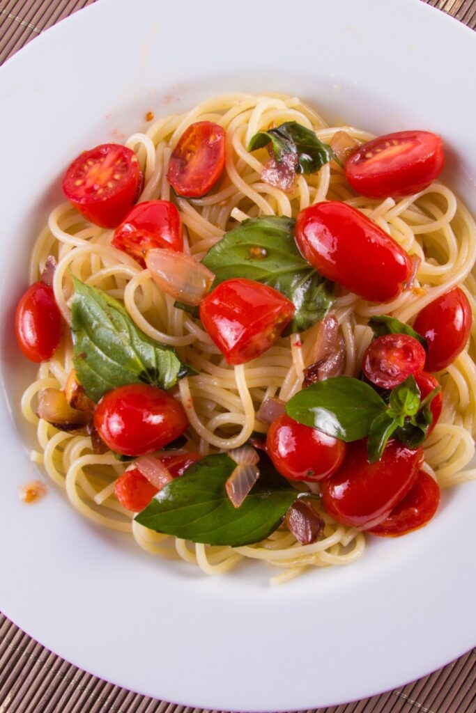 Bowl of Giada De Laurentiis Cherry Tomato Spaghetti with basil and cherry tomatoes.