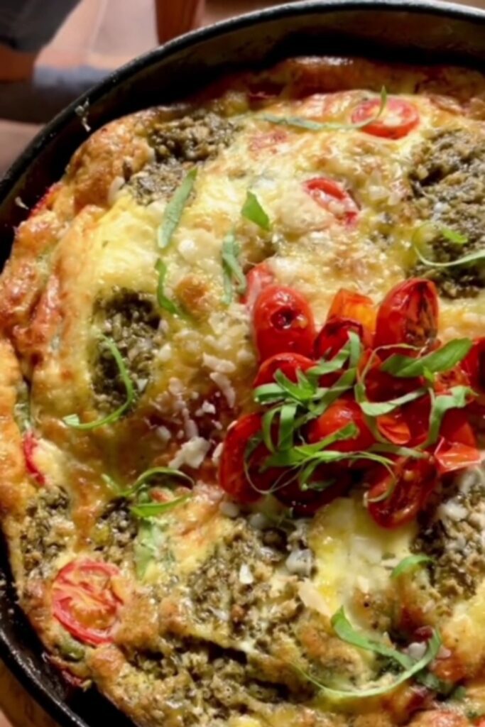 Giada De Laurentiis Caprese Frittata in a cast-iron skillet with cherry tomatoes and basil.