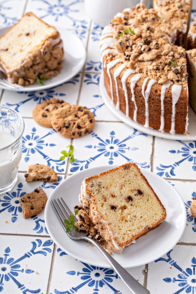 Giada De Laurentiis chocolate chip pound cake on a white cake stand with a slice being served.