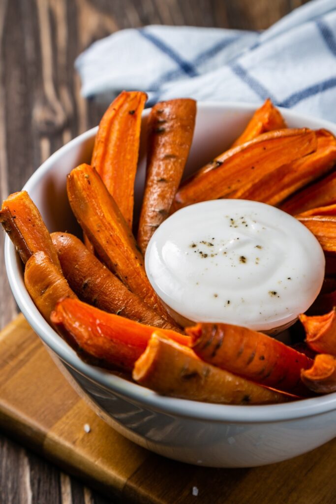 Carrot fries served in a bowl with a side of lemon-mint dip.