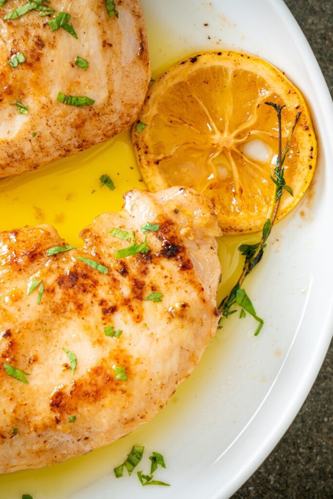 Amalfi Lemon Chicken with a slice of charred lemon on a white plate.