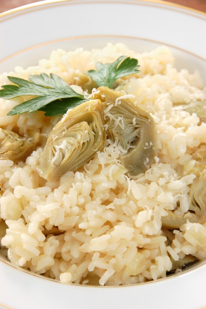 creamy artichoke risotto garnished with parsley and Parmesan cheese.