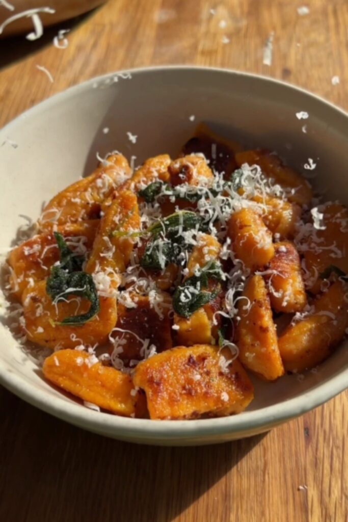 Giada Sweet Potato Gnocchi in a bowl with maple cinnamon sage brown butter and freshly grated Parmesan cheese.