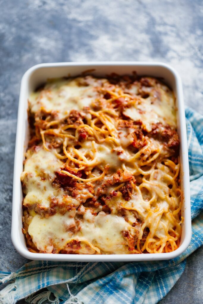  baked Bolognese with cheese in a white baking dish.